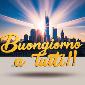 Un&#039;alba luminosa illumina i grattacieli di una città con il sole che sorge dietro di essi. Sopra la scena si legge &quot;Buongiorno a Tutti!!&quot;